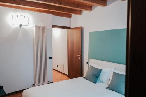 een slaapkamer met een wit bed met blauwe kussens bij SM Hospitality ZACCAGNI in Reggio Emilia