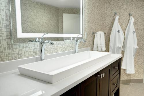 a bathroom with a white sink and a mirror at Sheraton Eatontown Hotel in Eatontown