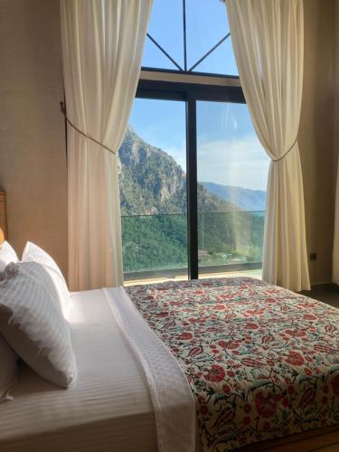 a bedroom with a bed and a large window at Hestia View in Fethiye