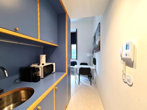 a bathroom with a sink and a kitchen with a microwave at Fisherman Blues in Matosinhos