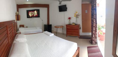 a bedroom with a bed and a tv on the wall at Casa ka'an in Isla Mujeres