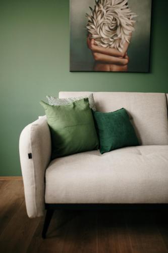 a white couch with two green pillows on it at VIP apartments Bitola in Bitola
