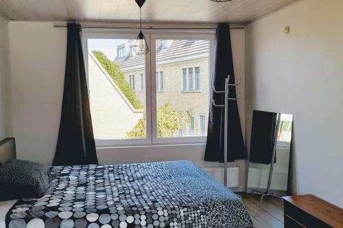 una camera con un letto e una grande finestra di Privé, mooi ingericht huis op toplocatie nabij bos a Watou