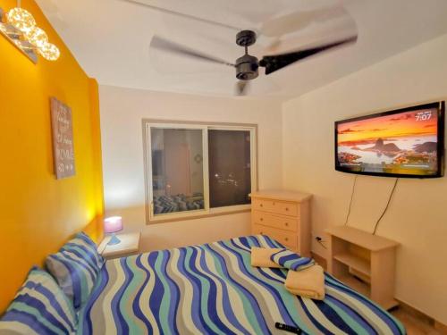 1 dormitorio con 1 cama y TV en la pared en Dep 304a En Casablanca Linda Suite Petfriendly cerca de todo, en Same