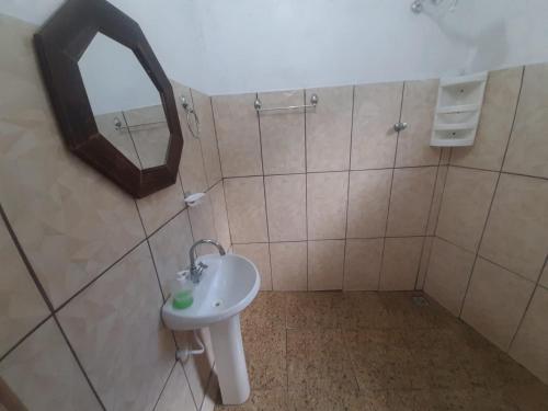 a bathroom with a sink and a mirror at Aparecida Akuto's Pousada in Aparecida