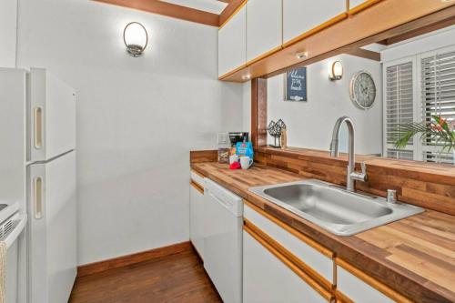 a kitchen with a sink and a white refrigerator at Kiahuna Plantation Unit 42, Air Conditioning, 2 Minute Walk to Beach in Koloa