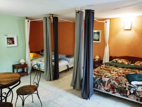 1 dormitorio con 2 camas, mesa y sillas en Chambres d'hôtes Microbrasserie & Auberge Ortan, en La Canourgue