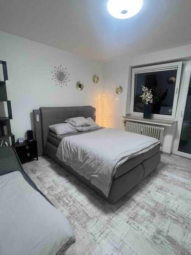 a bedroom with a large bed and a window at Modernes Apartment mit 75qm mit Balkon & Aussicht in Aachen