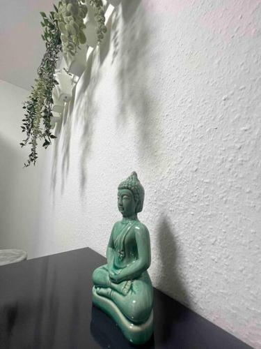 a green statue sitting on a table next to a wall at Modernes Apartment mit 75qm mit Balkon & Aussicht in Aachen