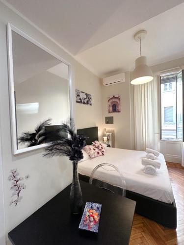 een slaapkamer met een bed met een spiegel en een tafel bij DUOMO Dreams [Hearth Of Gallery] in Milaan