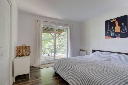 a white bedroom with a bed and a window at Eastern Township's Getaway! Beach + Ski Haven in Magog-Orford