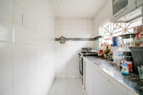 a kitchen with white tiled walls and a counter at HABITACION PRIVADA EN CASA DE MIS PADRES in Barranquilla