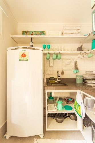 a kitchen with an open refrigerator and a sink at Casa d'Aroeira Residencial Boutique - Centro de Juqueí - 2 quadras do mar - Serviço de Praia - Roupa de Cama 600 fios algodão Egípcio - Toalhas Banho e Praia - Tudo Novo - Estacionamento Interno - Cozinha - Consulte unidades com Ofurô Hidro e Cromoterapia in Juquei