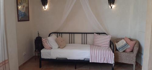 a bedroom with a bed and a chair with pillows at Darcilla Guest House in Tarifa