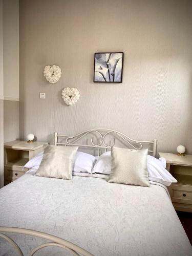 a bedroom with a white bed with two flowers on the wall at Guesthouse Villa Vice in Split