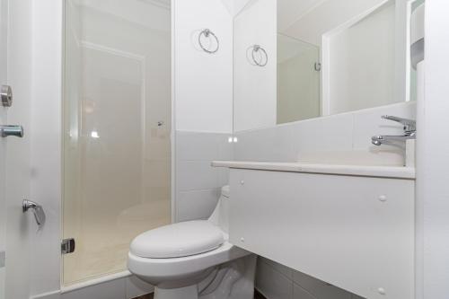 a white bathroom with a toilet and a shower at Hotel Ossido Nero in Viña del Mar