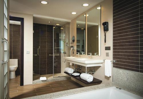 uma casa de banho com um lavatório, uma banheira e um espelho. em Riu Reggae - Adults Only - All Inclusive em Montego Bay