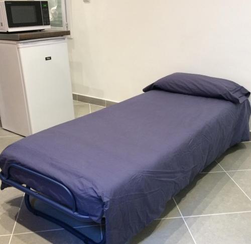 - un lit avec une couette violette dans l'établissement Telerues, à Nice