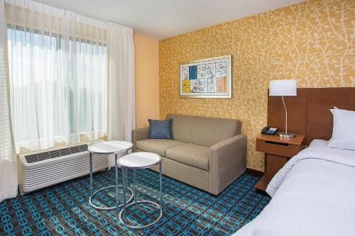 a hotel room with a bed and a couch and a window at Fairfield Inn & Suites by Marriott Nashville Hendersonville in Hendersonville