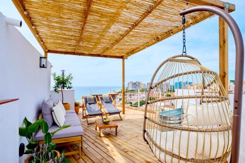 a patio with a swing on a roof at El Rancho at the Beach in Blanes