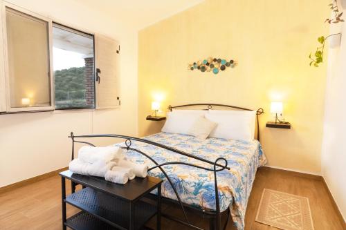 a small bedroom with a bed and a table at Agriturismo Sa Jana Holidays - Adults Only in Cardedu