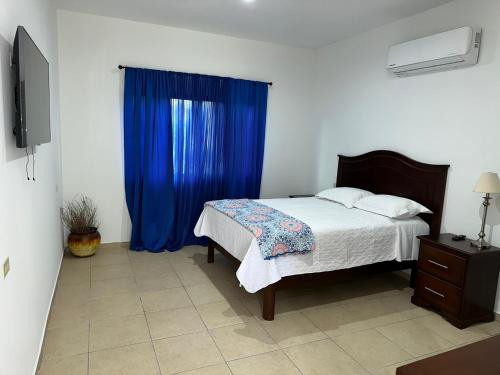 a bedroom with a bed and a blue curtain at Real Paraiso in Juticalpa