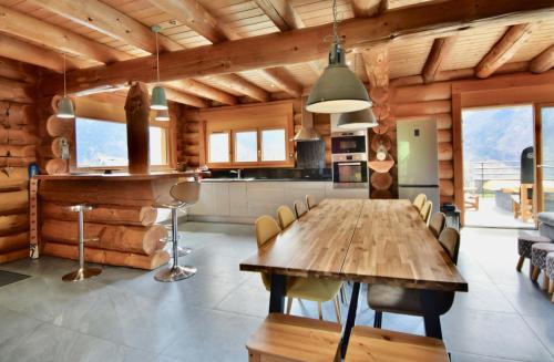 a kitchen and dining room with a wooden table and chairs at L'Etoile du Berger in Saint-Martin-de-la-Porte