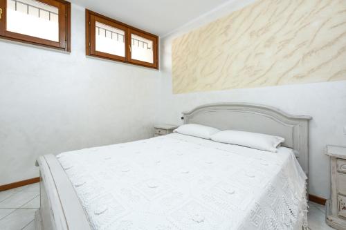 1 dormitorio blanco con 1 cama blanca y 2 almohadas en Manerba CENTRO GardaSee e parcheggio, en Manerba del Garda