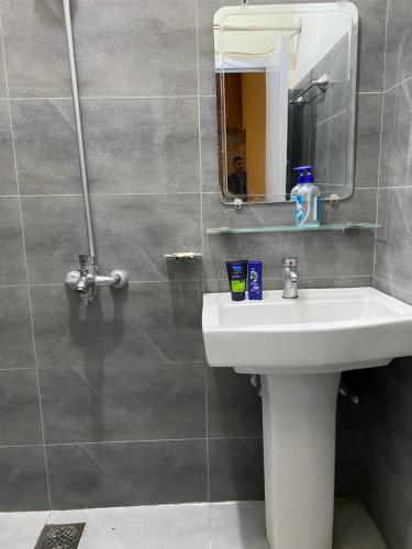 ein Bad mit einem Waschbecken und einem Spiegel in der Unterkunft Durrani House in Islamabad