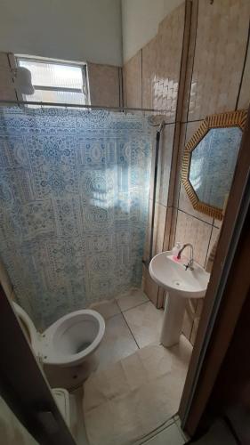 a bathroom with a toilet and a sink at Aparecida Akuto's Pousada in Aparecida