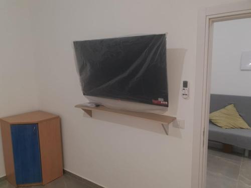 TV de pantalla plana colgada en la pared en חיים בגלבוע, 