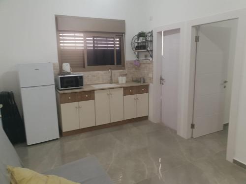 een keuken met witte kasten en een witte koelkast bij חיים בגלבוע 