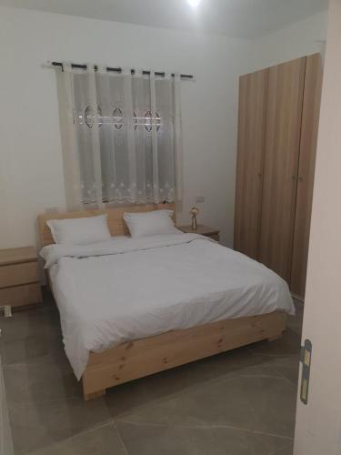 1 dormitorio con 1 cama grande con sábanas y almohadas blancas en חיים בגלבוע, 