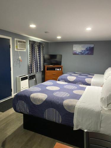 um quarto de hotel com duas camas e uma televisão em Dunmore Inn em Dunmore