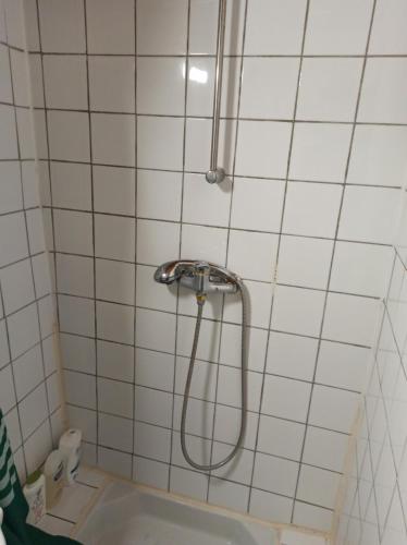 La salle de bains carrelée de blanc est pourvue d'une douche et d'une baignoire. dans l'établissement STUDIO DE Manon, à Allauch