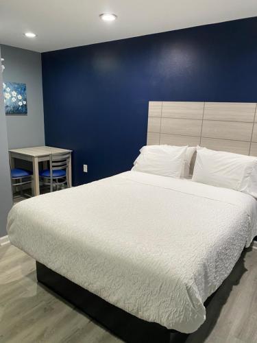a bedroom with a large bed with a blue wall at Dunmore Inn in Dunmore