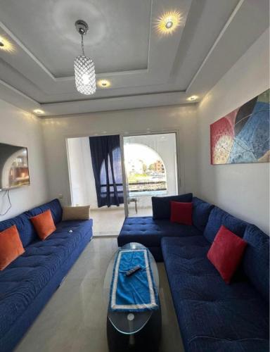 a living room with a blue couch and red pillows at Spacious 2-Bedroom Apartment in Martil