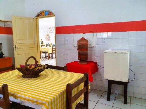 uma cozinha com uma mesa com uma taça de fruta em Pousada Sonho Meu em Porto Seguro