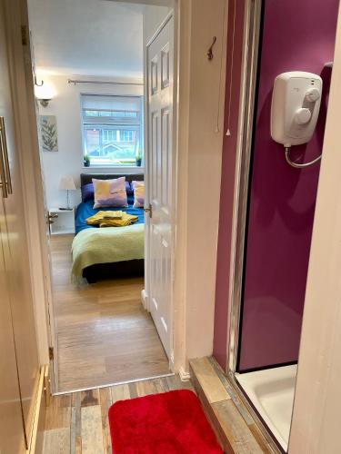 ストラトフォード・アポン・エイボンにあるBoscoteのベッド1台と赤い敷物が備わる小さな客室です。