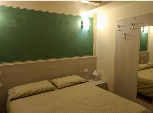 una camera da letto con una tavola verde sopra un letto di Osteria Carli B&B a Gratacasolo