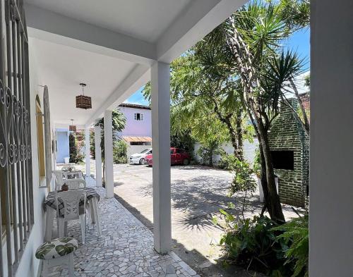 塞古羅港的住宿－Pousada Sonho Meu，一个带白色椅子和棕榈树的庭院