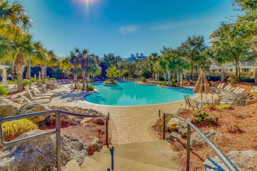 a swimming pool with palm trees in a resort at The Grand #2703 in Destin