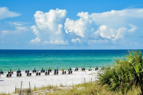 a beach with a lot of chairs and the ocean at The Grand #2703 in Destin