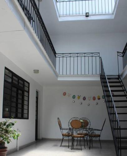 a dining room with a table and chairs and stairs at Casa Tenorio Hospedaje in Orizaba