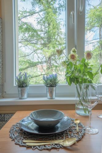 a table with a bowl and flowers on a window sill at Apartament Premium Salt in Wieliczka