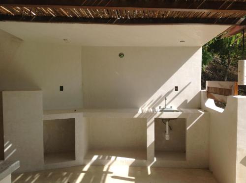 a white kitchen with a sink and a staircase at Casa Flor de Mar in Zipolite