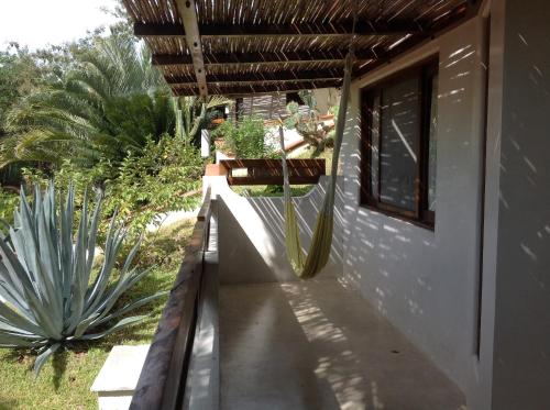 a house with a balcony with a window and a cactus at Casa Flor de Mar in Zipolite