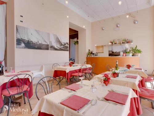 a restaurant with tables and chairs with red napkins at Hotel Medusa in Finale Ligure