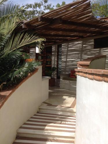 a house with a wooden roof and a staircase at Casa Flor de Mar in Zipolite