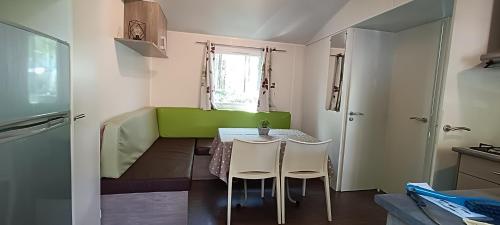a small kitchen with a table and chairs in a room at Mobilhome climatisé 3 chambres à 30 min du Puy du F et de Nantes in La Boissière-de-Montaigu